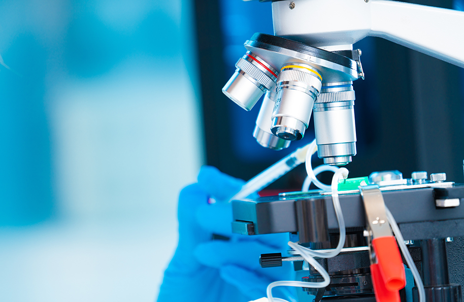 technician girl with microfluidic device LOC in microbiological lab